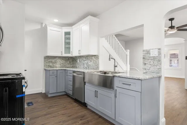 a kitchen with granite countertop cabinets stainless steel appliances and a wooden floor