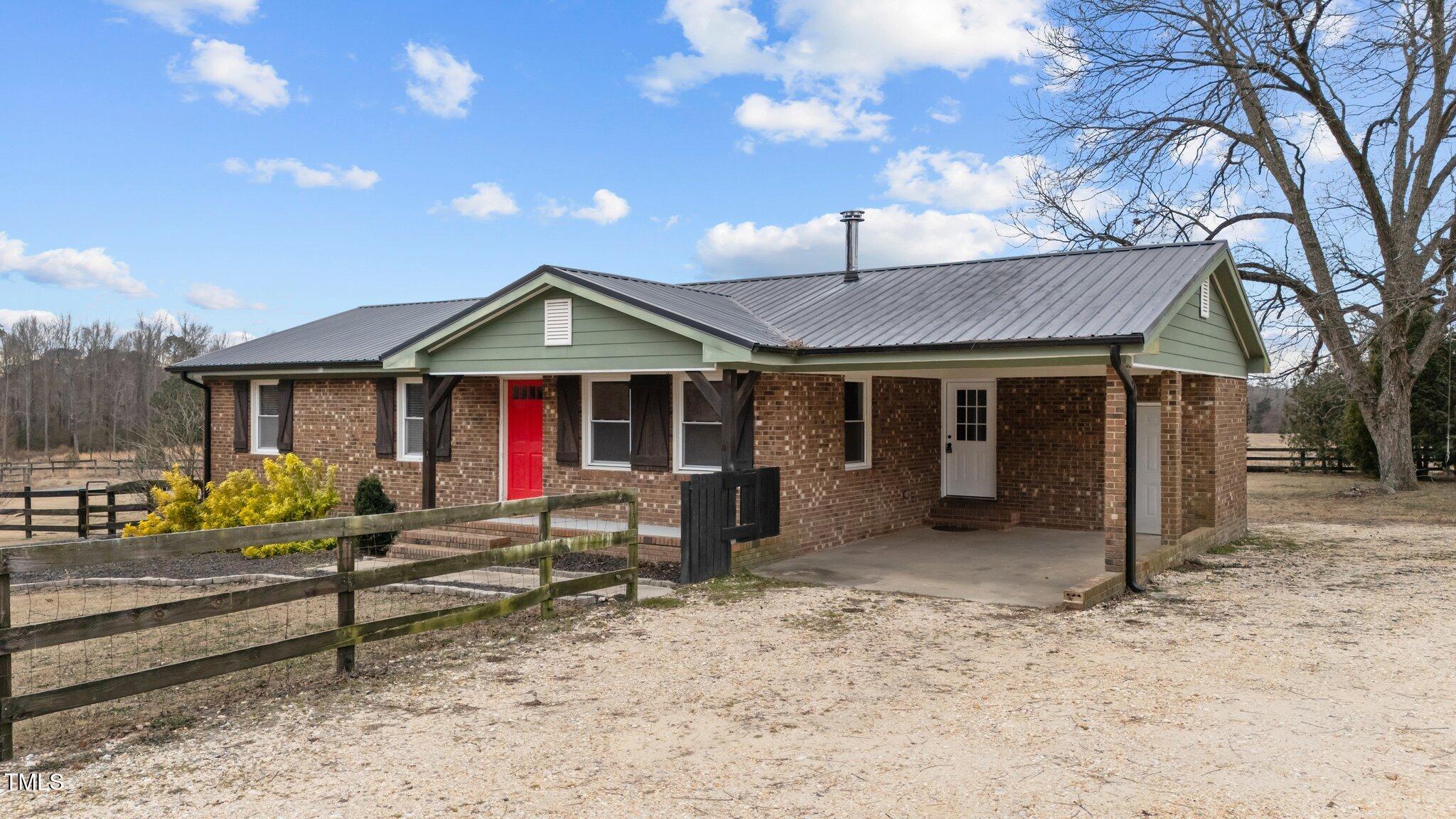 a view of a house with a yard and sitting area