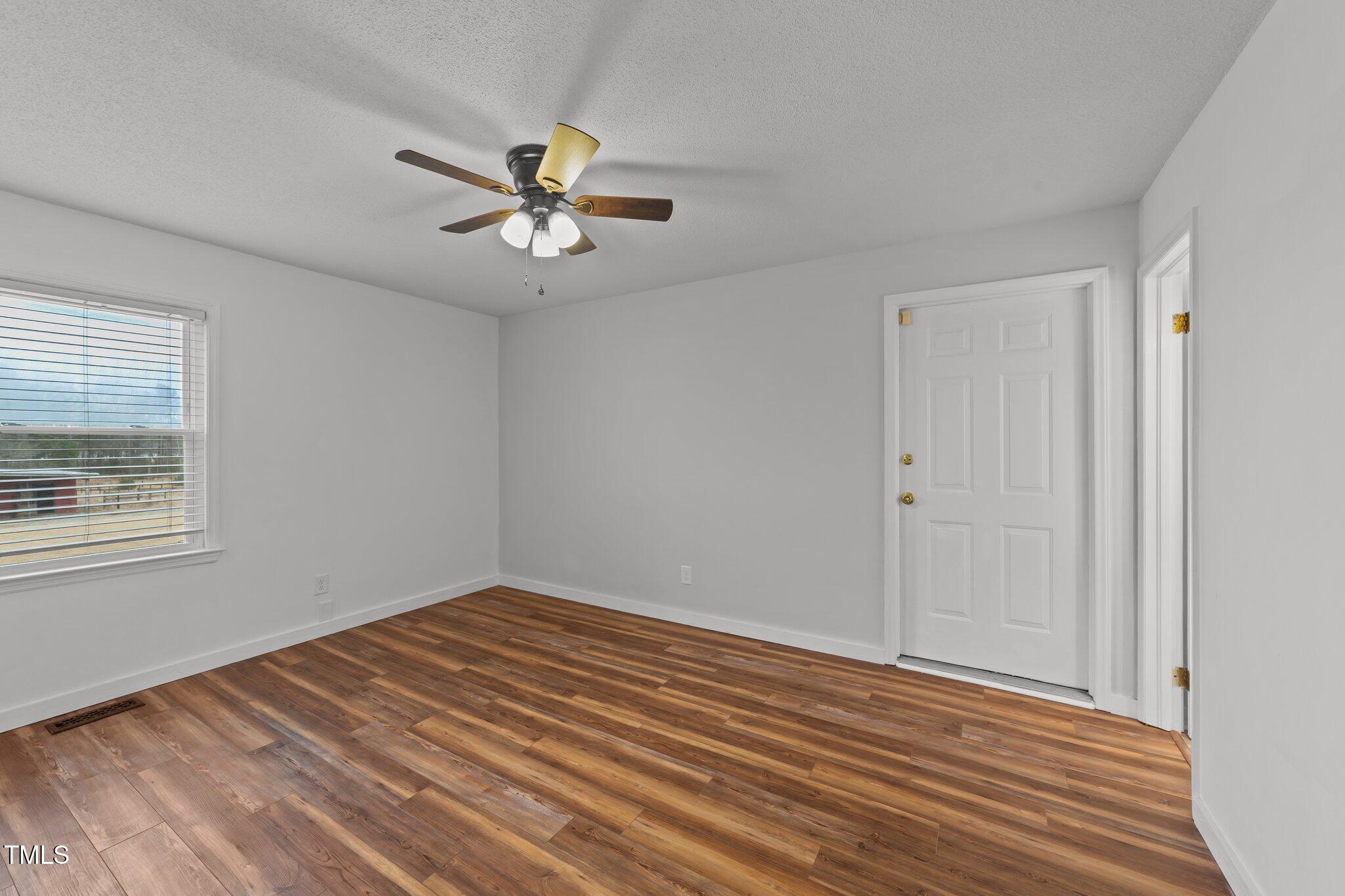 593 Bailey Road Coats, NC 27521 - Photo 20 of 38 a view of empty room with wooden floor and fan