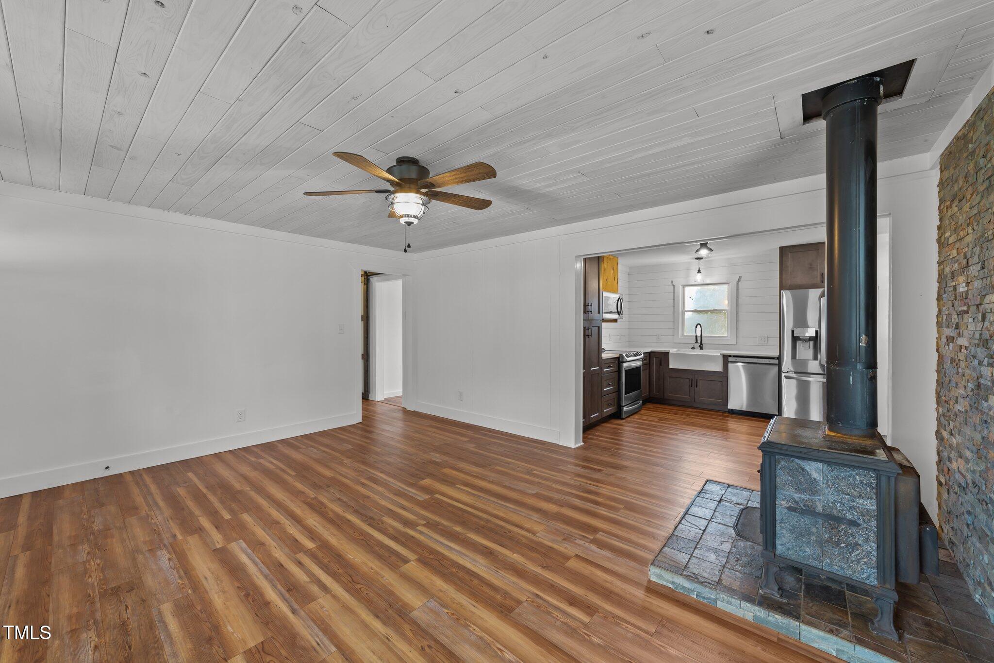 593 Bailey Road Coats, NC 27521 - Photo 4 of 38 a view of a livingroom with wooden floor and a ceiling fan