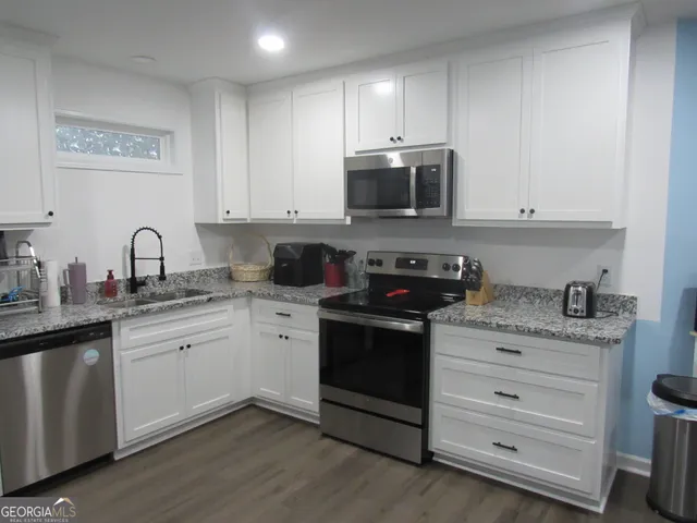 a kitchen with stainless steel appliances granite countertop a sink stove and microwave