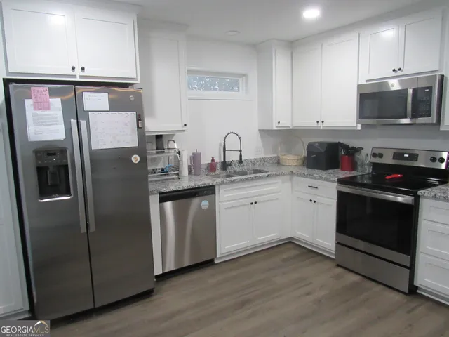 a kitchen with stainless steel appliances a refrigerator sink and microwave
