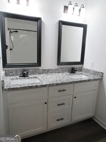 a bathroom with a granite countertop toilet sink and mirror