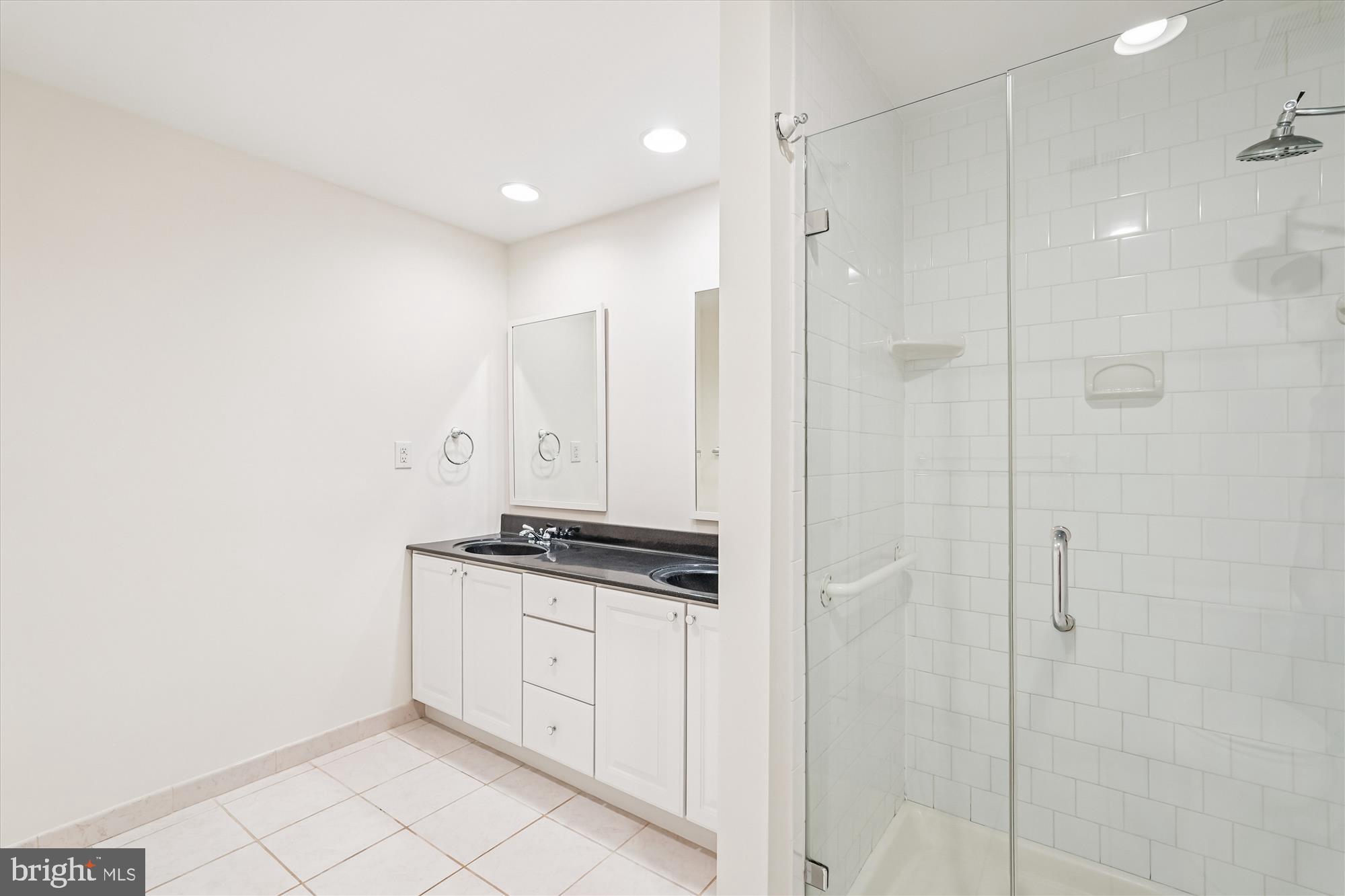 11410 Running Cedar Road Reston, VA 20191 - Photo 30 of 56 a bathroom with a granite countertop sink a mirror and shower
