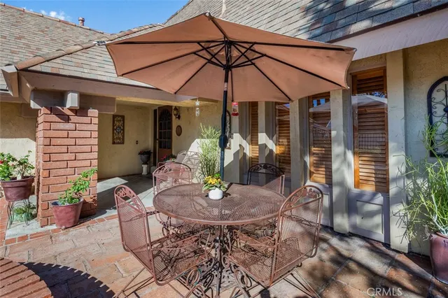 a patio with a table and chairs under an umbrella