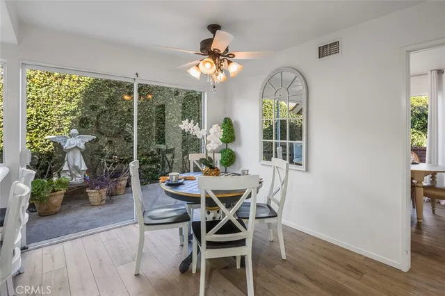 a dining room with furniture potted plants and wooden floor
