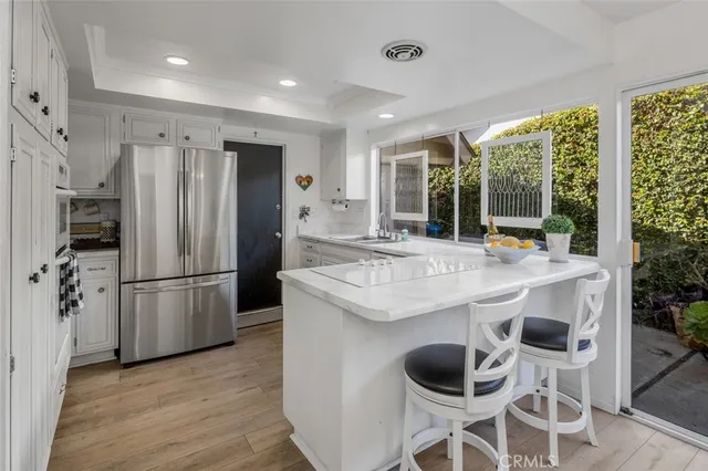 a kitchen with stainless steel appliances granite countertop a kitchen island a stove a refrigerator and a sink