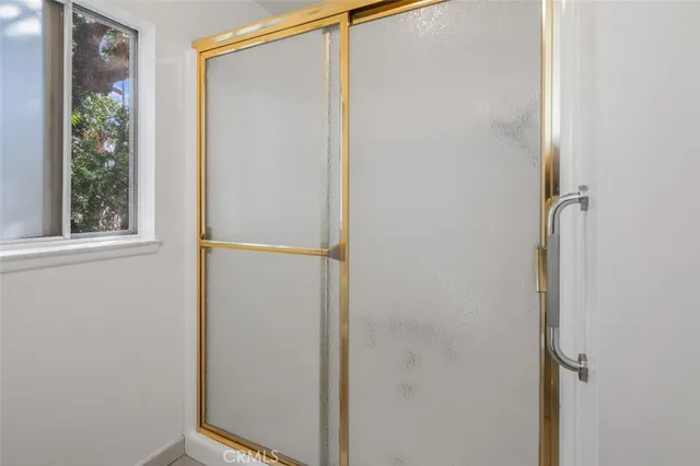 a bedroom with a bed painting on the wall and a window