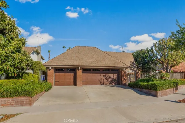 a front view of a house with a yard and a garden