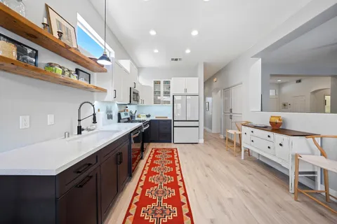 a large kitchen with granite countertop a sink and cabinets