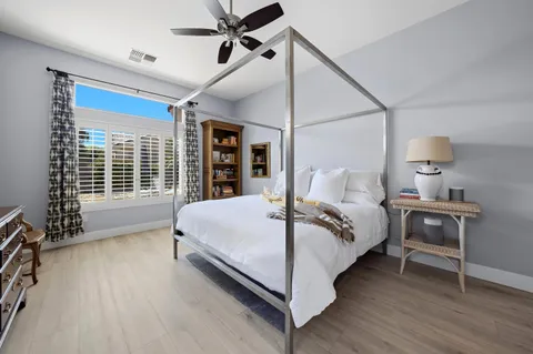 a large bedroom with a bed and wooden floor