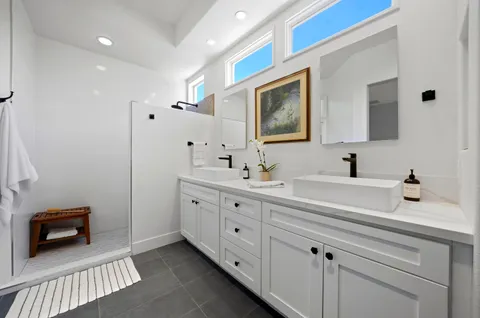 a spacious bathroom with a double vanity sink a mirror and a