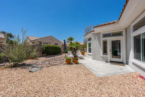 a view of a house with backyard outdoor seating and covered with furniture