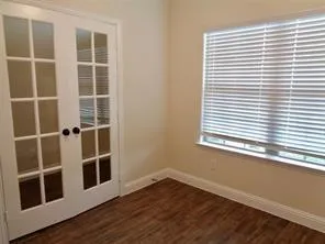 a view of a hardwood floor and windows in a room