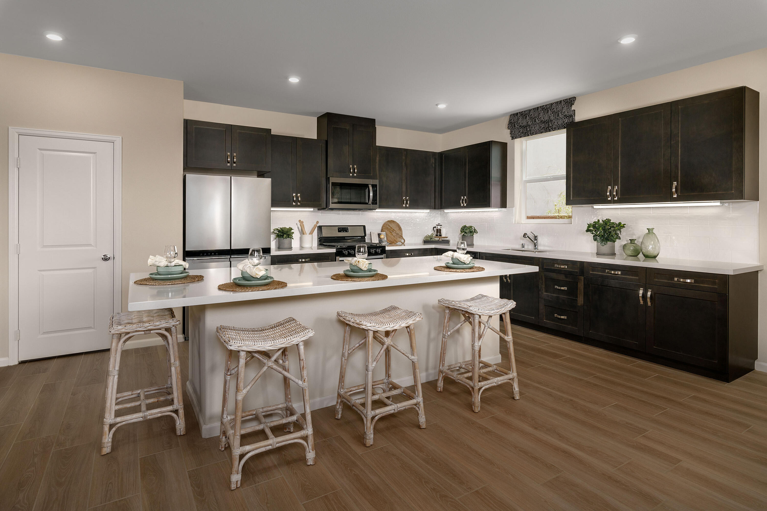 79687 Bolton Drive Indio, CA 92203 - Photo 4 of 13 a kitchen with stainless steel appliances kitchen island granite countertop a table chairs sink and cabinets