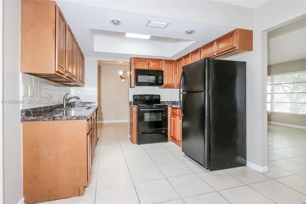a kitchen with stainless steel appliances granite countertop a refrigerator and a stove