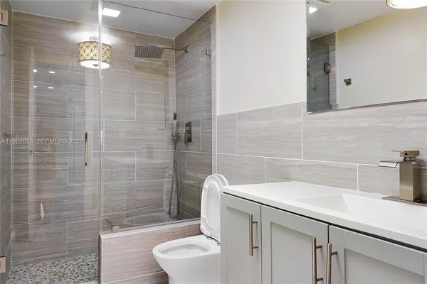 a bathroom with a sink a toilet and shower