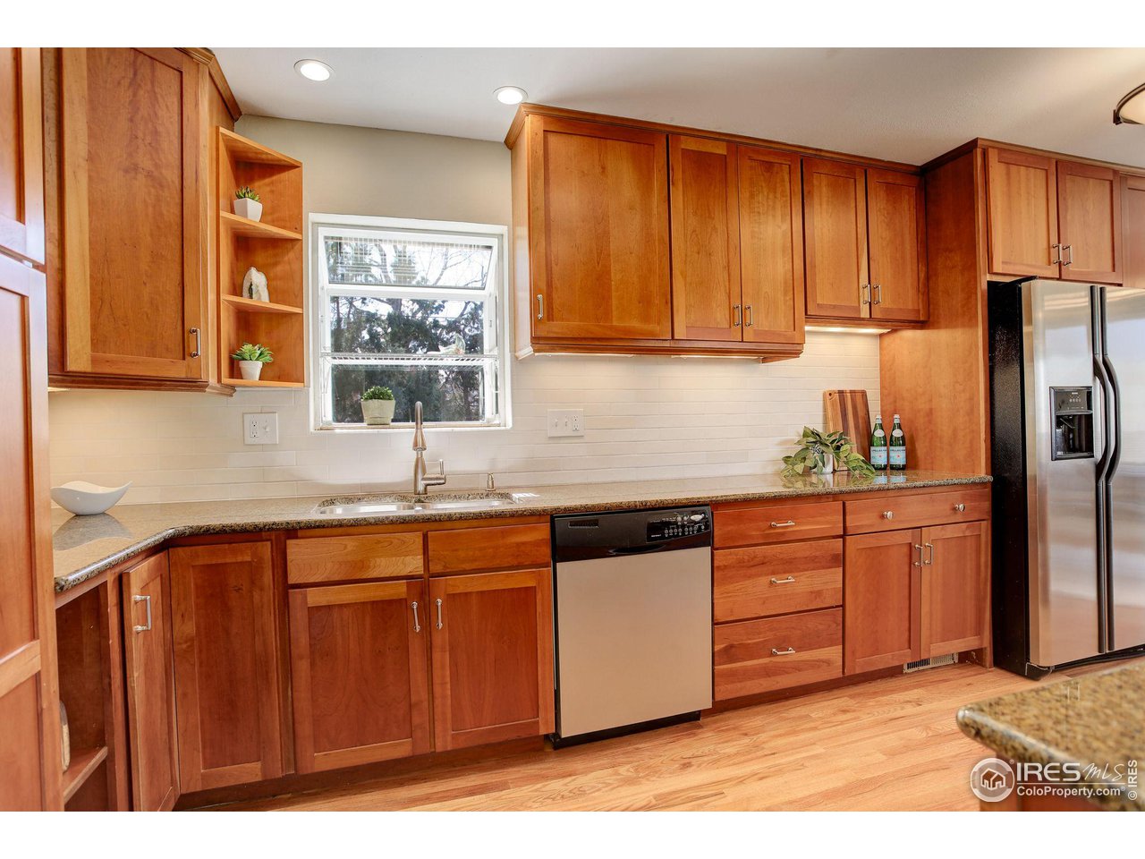 4361 Butler Circle Boulder, CO 80305 - Photo 11 of 39 a kitchen with stainless steel appliances granite countertop a refrigerator a sink dishwasher and wooden cabinets with wooden floor
