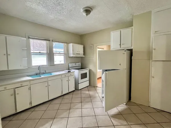 a kitchen with a refrigerator sink and cabinets