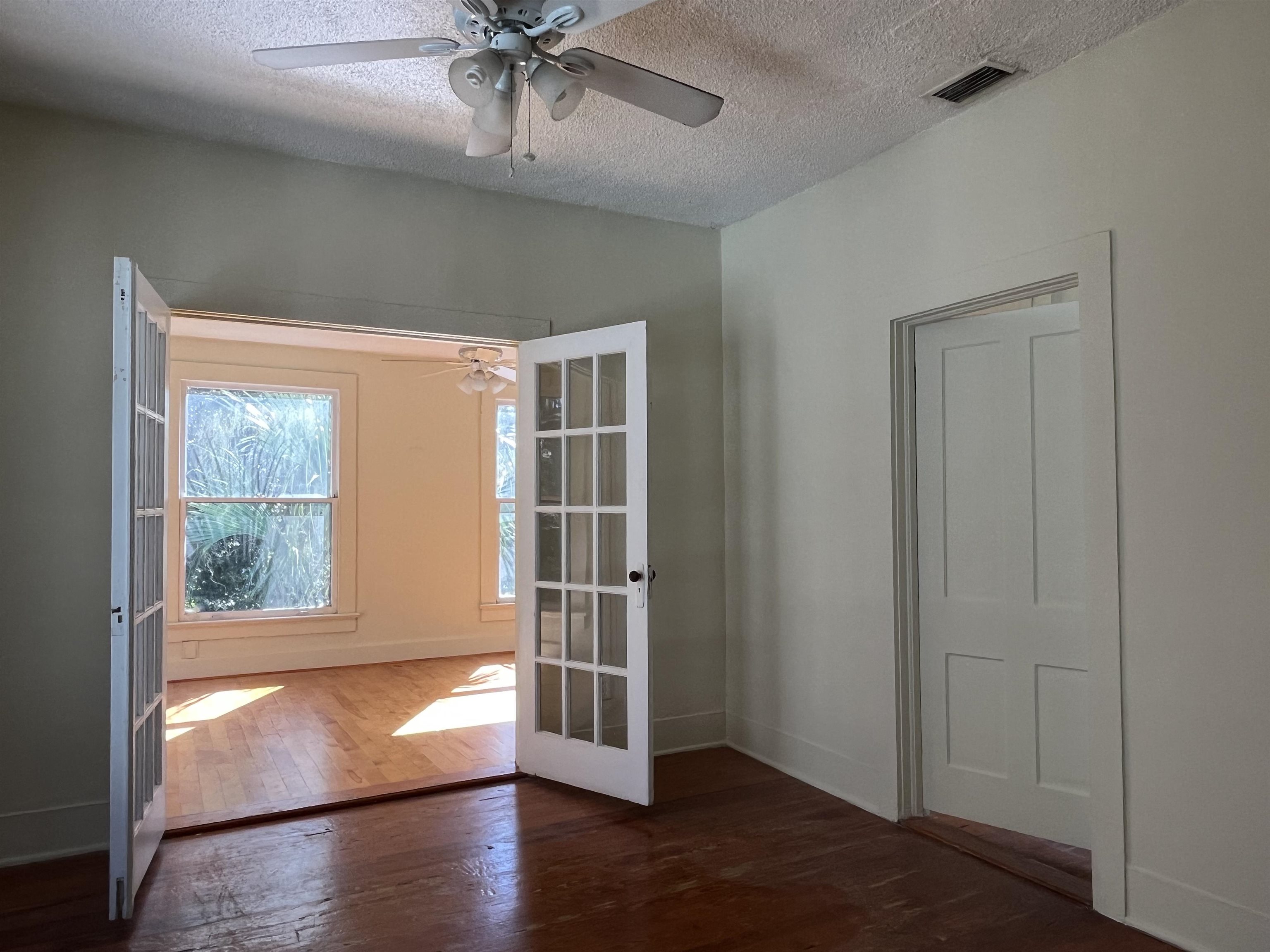 114 Bridge Street, Unit B St. Augustine, FL 32084 - Photo 8 of 14 an empty room with wooden floor and windows