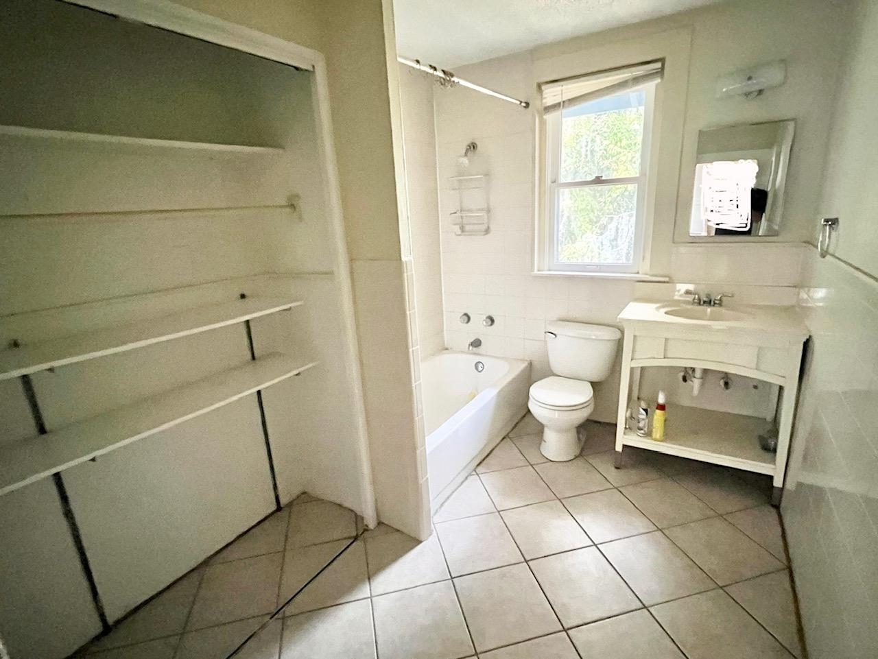 114 Bridge Street, Unit B St. Augustine, FL 32084 - Photo 9 of 14 a bathroom with a sink a toilet and a mirror