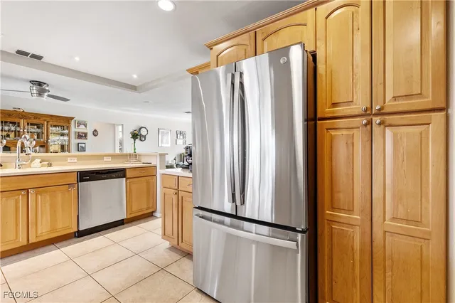 a kitchen with stainless steel appliances granite countertop a refrigerator a sink and white cabinets