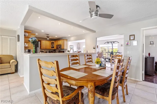 a dining room with stainless steel appliances kitchen island granite countertop a dining table and chairs