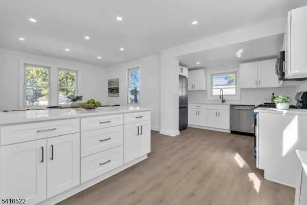 a kitchen with white cabinets and sink