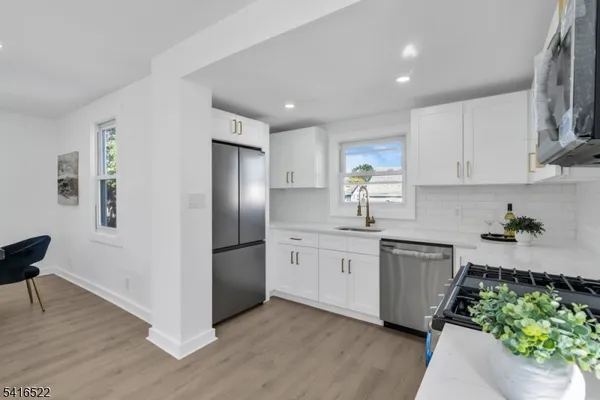a kitchen with stainless steel appliances granite countertop a refrigerator sink and stove