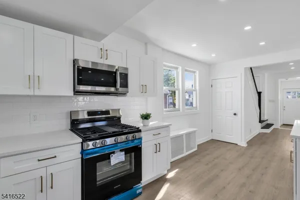 a kitchen with stainless steel appliances a stove a microwave and cabinets