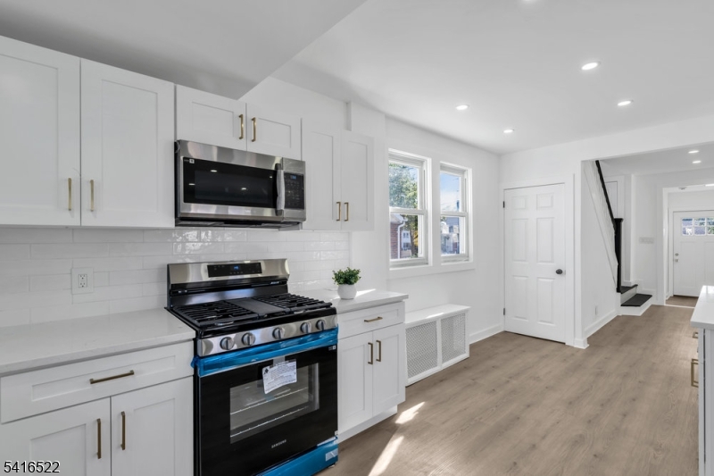 288 Harrison Street Nutley, NJ 07110 - Photo 10 of 21 a kitchen with stainless steel appliances a stove a microwave and cabinets
