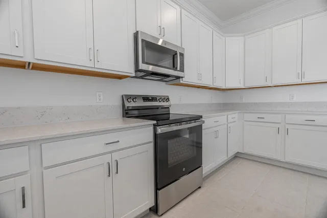 a kitchen with white cabinets and white appliances