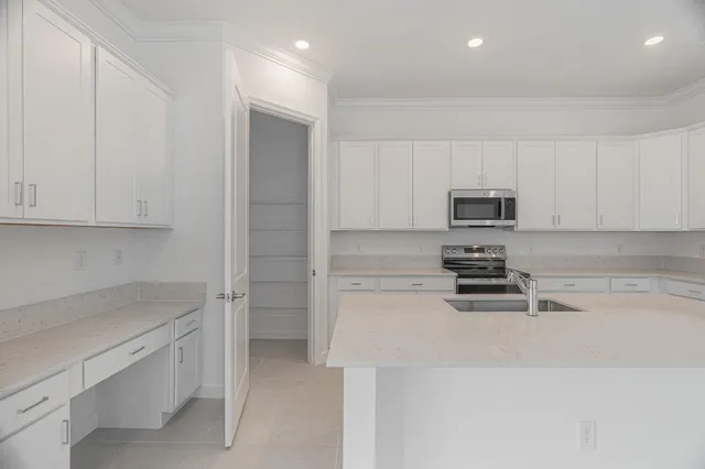 a kitchen with white cabinets and appliances