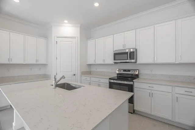 a kitchen with white cabinets and stainless steel appliances
