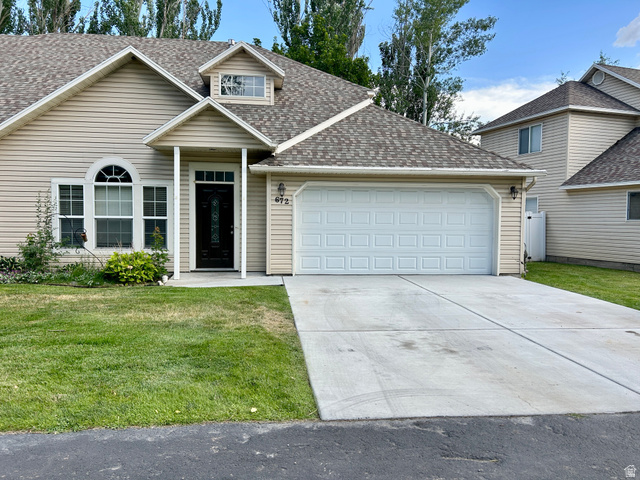 672 West 720 South Logan, UT 84321 - Photo 1 of 15 Two-story residence featuring light-colored siding, a dark asphalt shingle roof, and a two-car garage