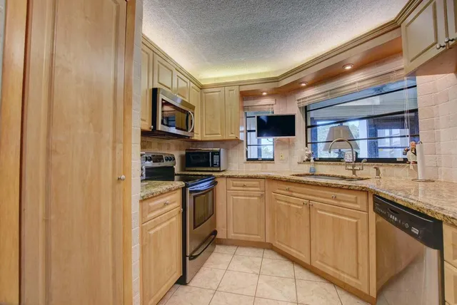 a kitchen with stainless steel appliances granite countertop a stove sink and cabinets