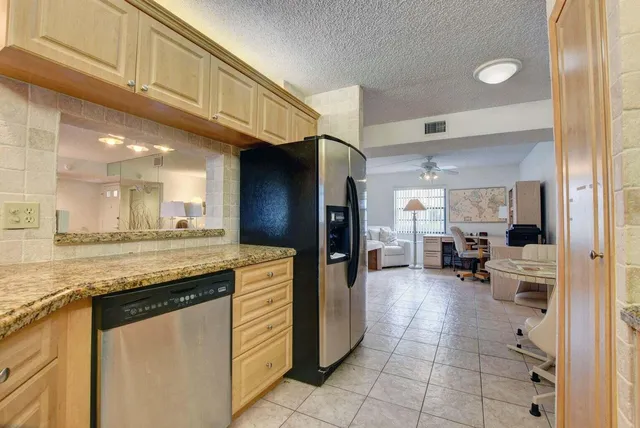a kitchen with kitchen island granite countertop wooden cabinets a sink and appliances