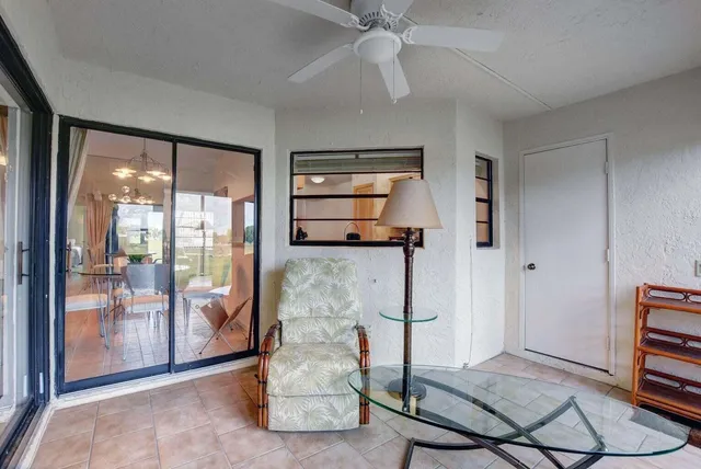 a living room with furniture a flat screen tv and a floor to ceiling window