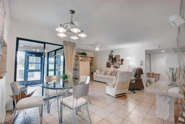 a living room with furniture a chandelier and a dining table