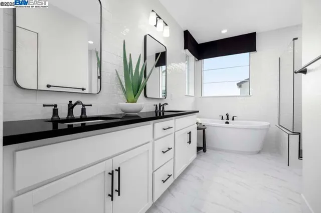 a bathroom with a double vanity sink a mirror and a bathtub