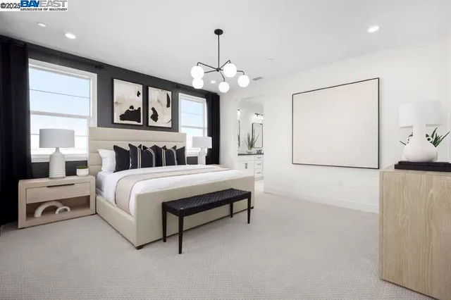 a bedroom with a large bed and a chandelier