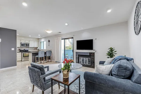 a living room with furniture a flat screen tv and a fireplace