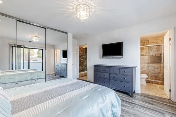 a spacious bedroom with a bed and a flat screen tv