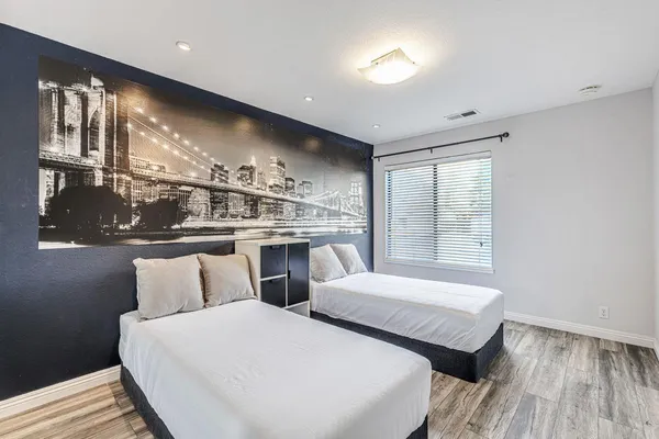 a bedroom with two beds and a dresser