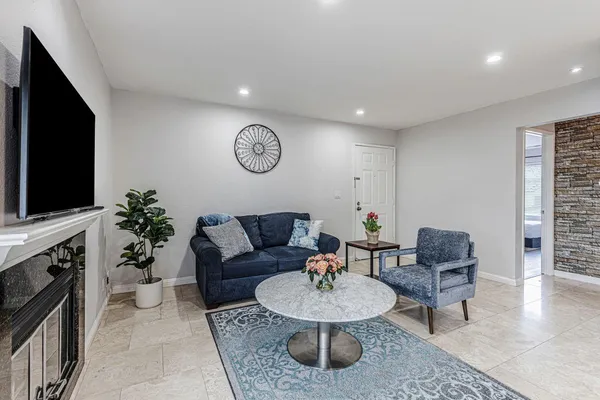 a living room with furniture a flat screen tv and a fireplace