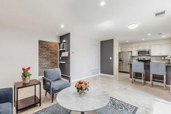 a living room with furniture and kitchen view
