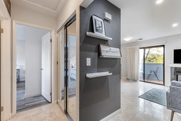 a view of a hallway with wooden floor and a living room