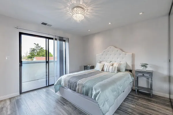 a bedroom with a large bed and a chandelier