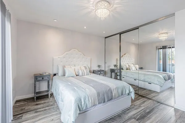 a bedroom with a large bed and a chandelier