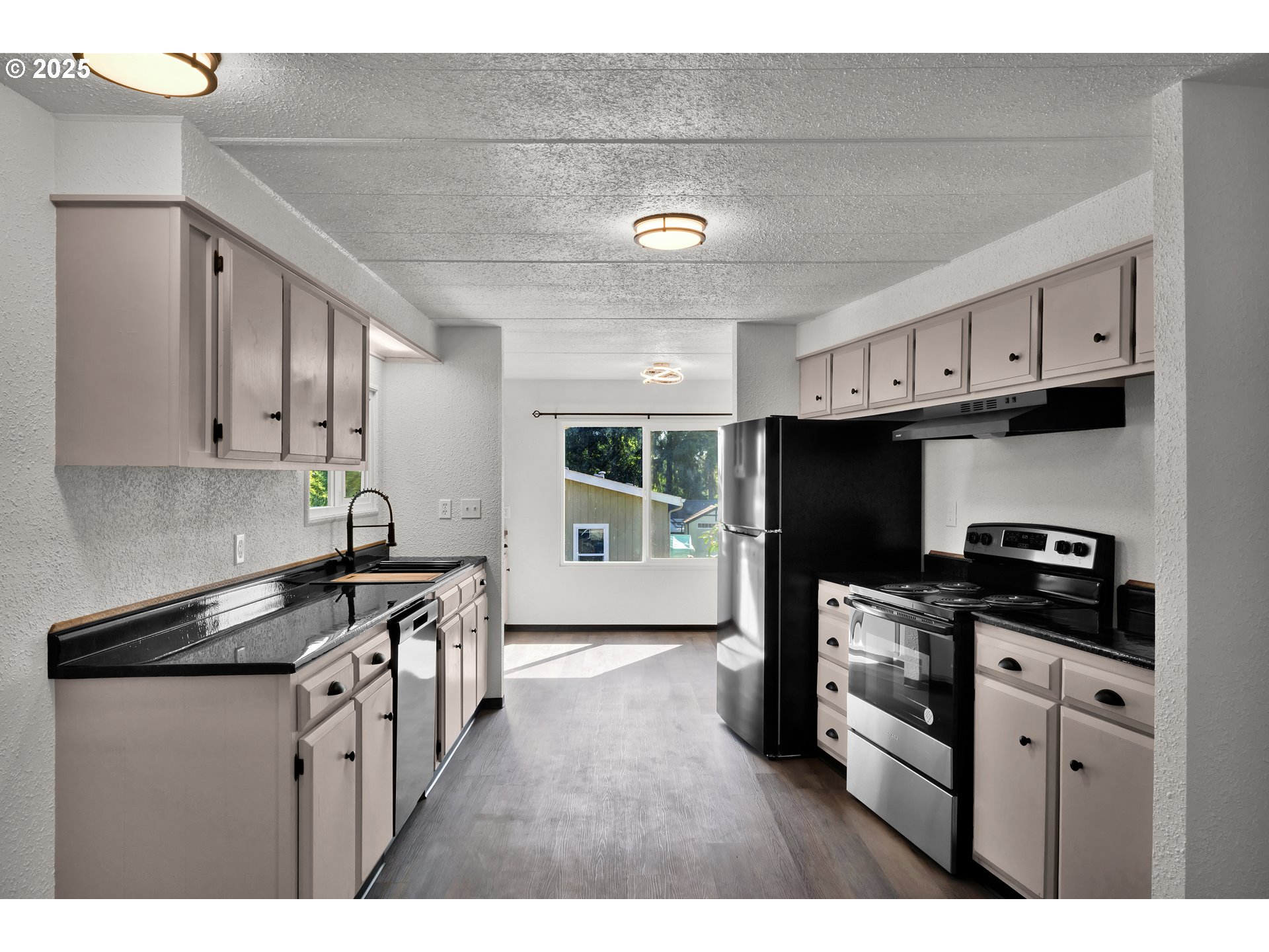 5055 Northeast Elliott Circle, Unit 8 Corvallis, OR 97330 - Photo 12 of 35 a kitchen with stainless steel appliances a sink a stove a refrigerator cabinets and a window